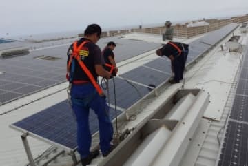 Técnicos de Insmoelca instalando placas solares en cubierta