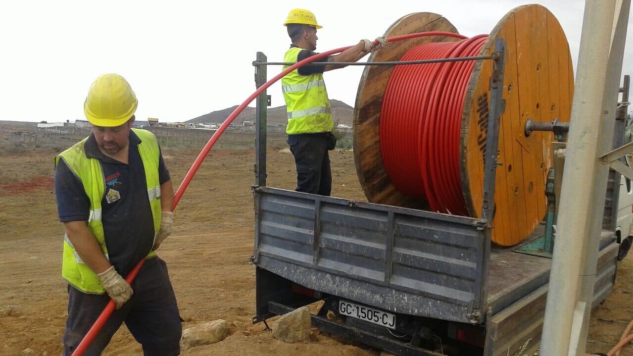 Operarios de Insmoelca tendiendo cable desde una bobina